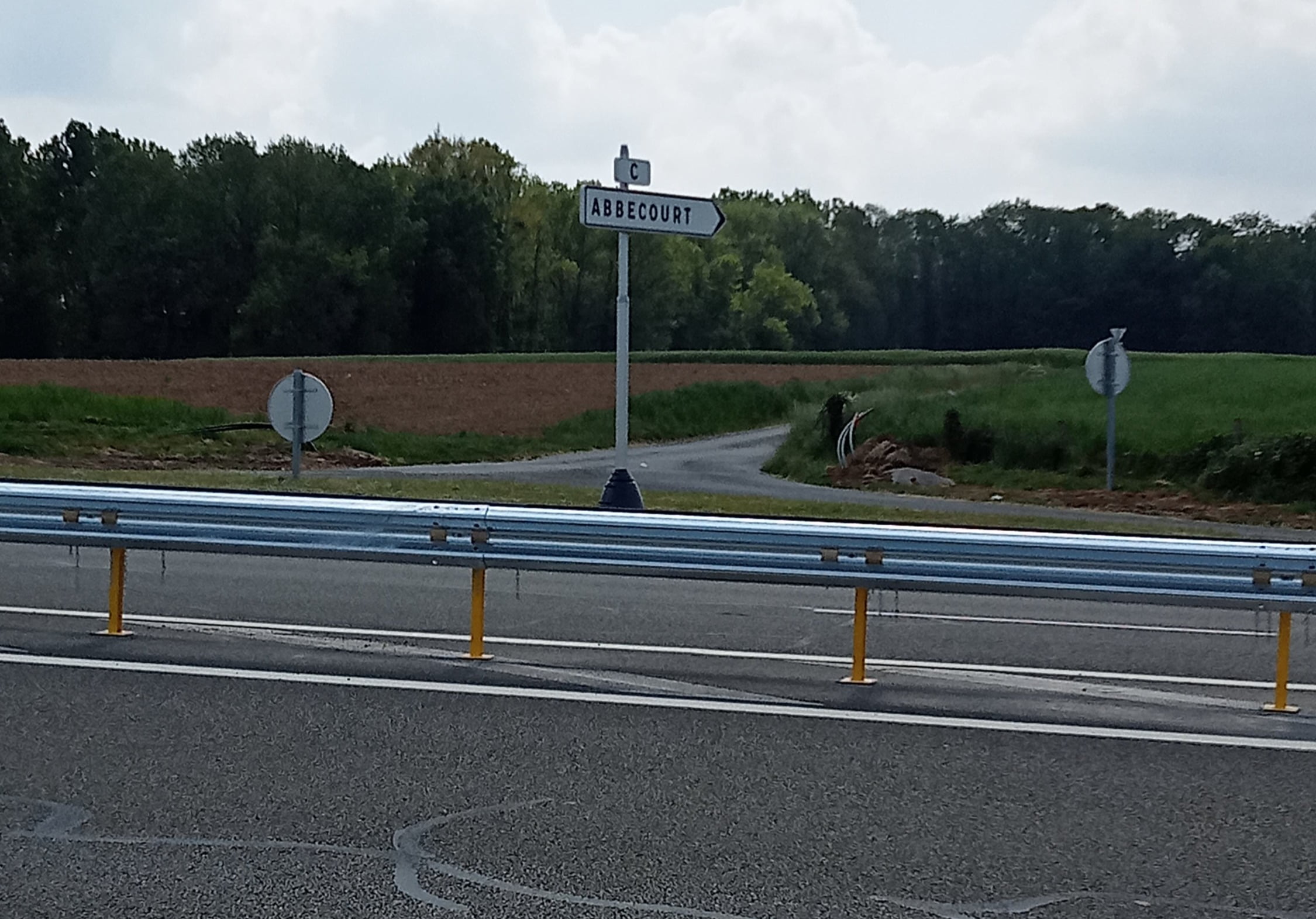 Panneau Abbecourt et barrière de sécurité au croisement de la D1001