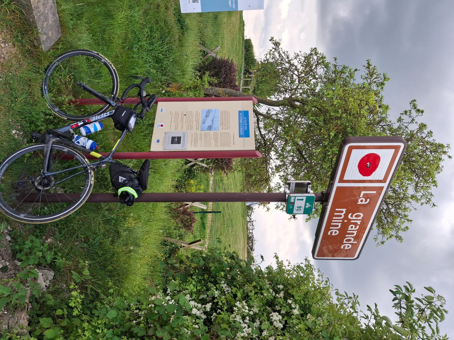 Vélo de randonnée stationné devant le panneau d'information de La Grande Mine lors du BRM 300 km 2026