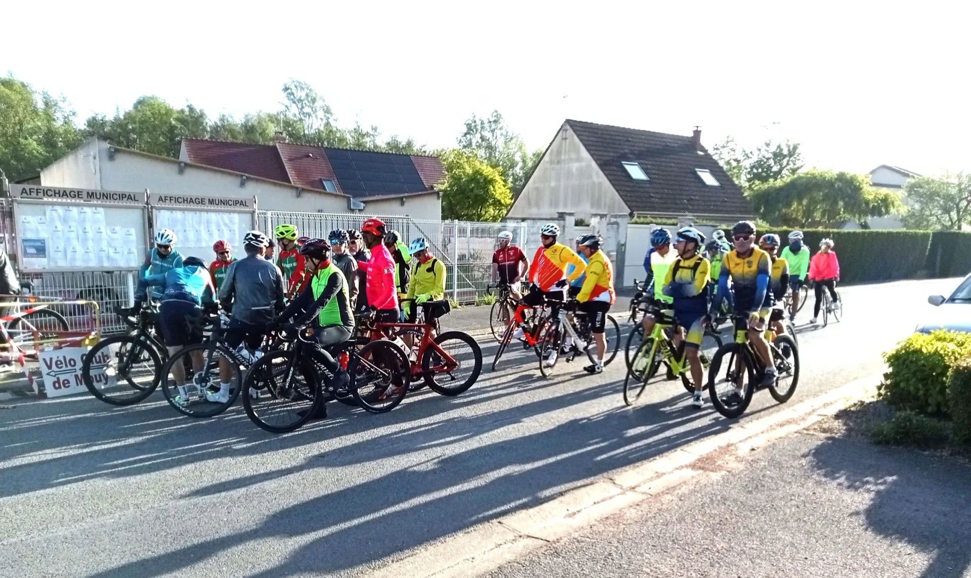 Peloton de cyclotouristes au départ du Picardo Normand 2026 devant l'affichage municipal de Mouy