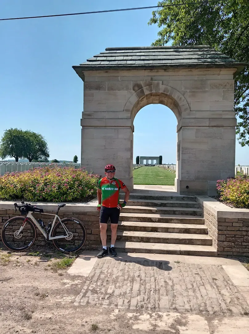 Cycliste du VC Mouy devant l'entrée d'un mémorial de la Grande Guerre dans la Somme