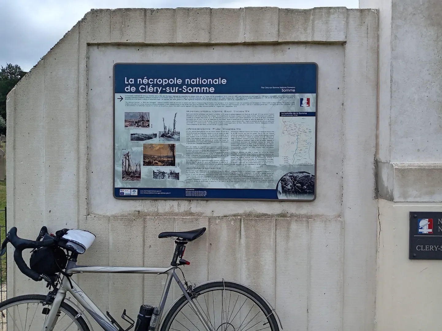 Vélo devant un panneau de nécropole nationale sur le parcours de la Grande Guerre