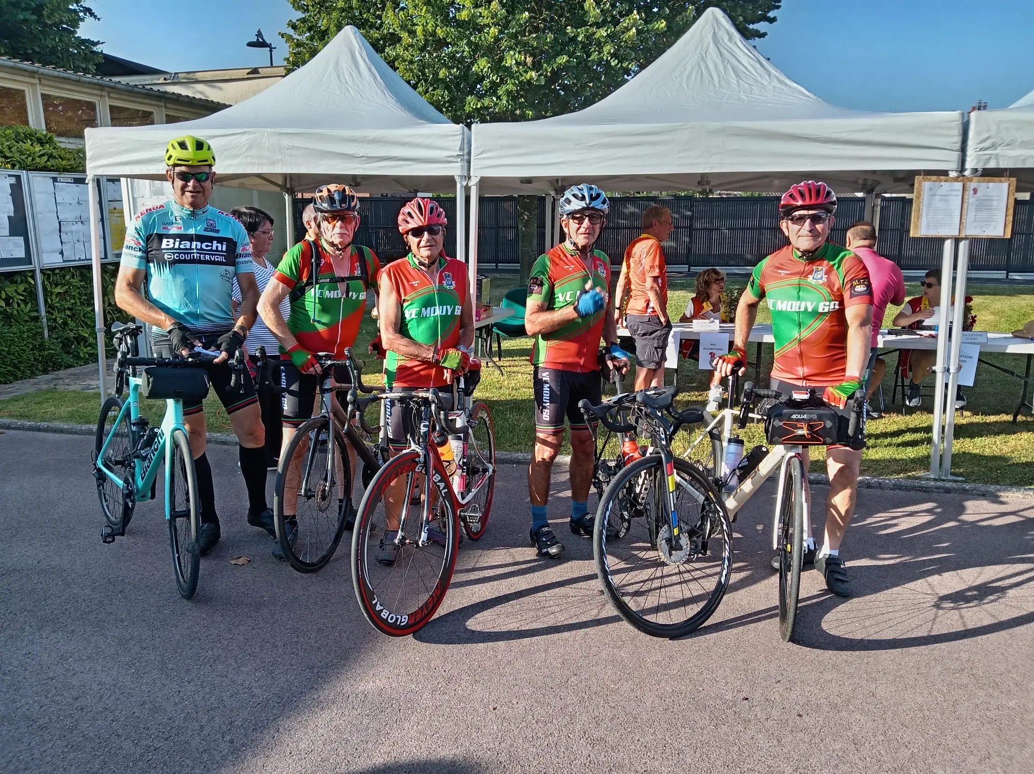 Les cinq Mouysards posant avec leurs vélos devant les tentes du stand d'inscription de la Tilloisienne à Tillé le 21 juin 2026